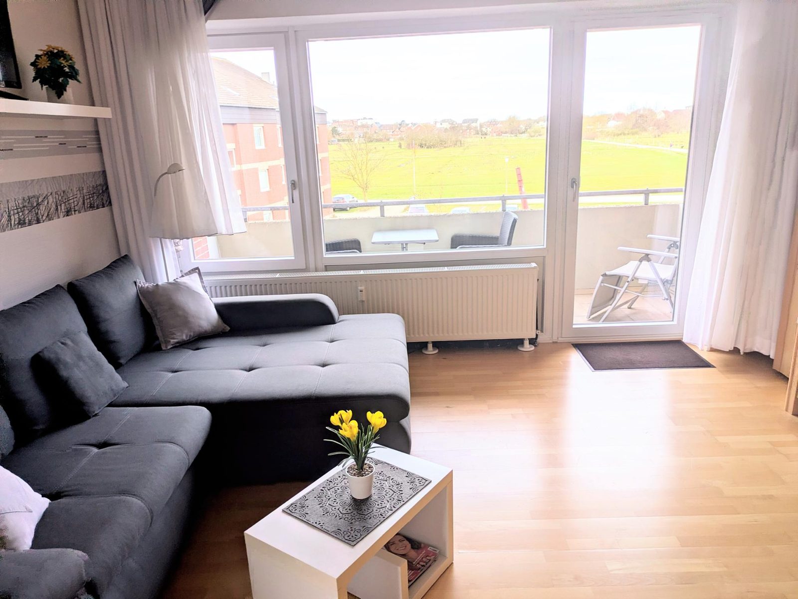 Wohnraum mit Blick auf den Balkon und die Pferdewiesen